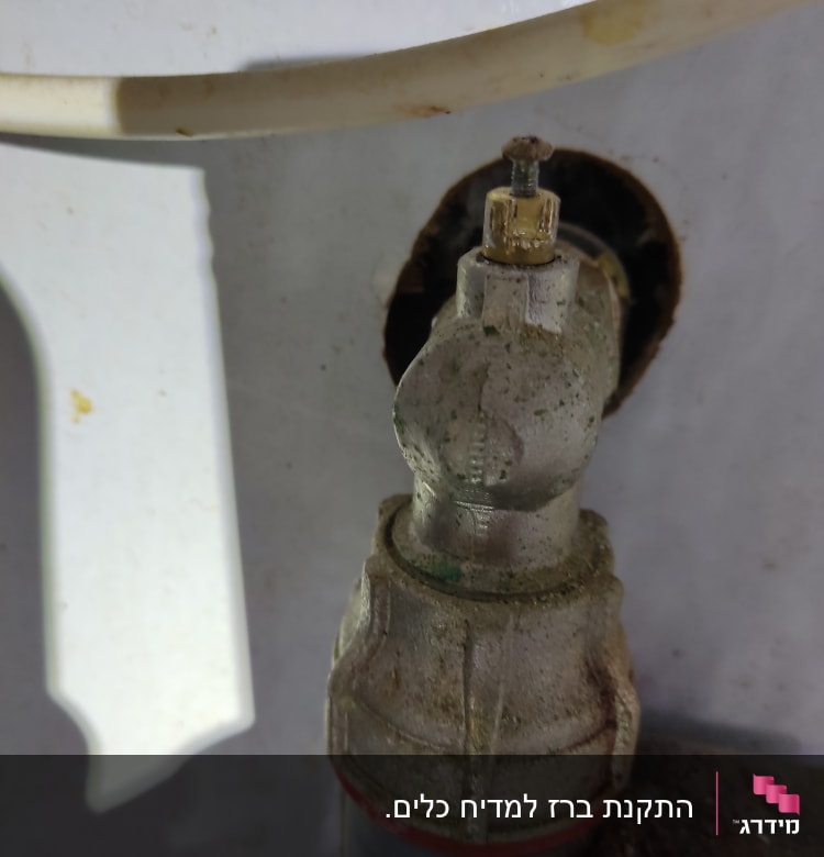 ברז מתכת עם צינור מחובר, מעט חלודה